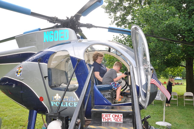 Boy in Louisville Police helicopter cockpit with woman seated behind him.